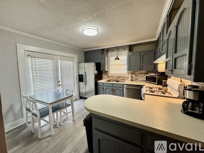 A kitchen with a table and chairs in front of a window.
