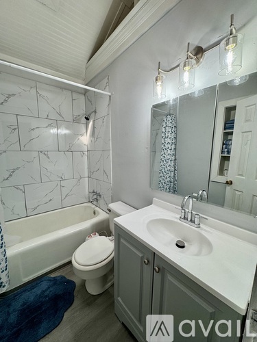 A bathroom with a marble tile wall and a white sink.