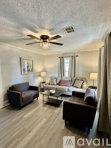 A living room with a brown couch, a chair, and a coffee table.