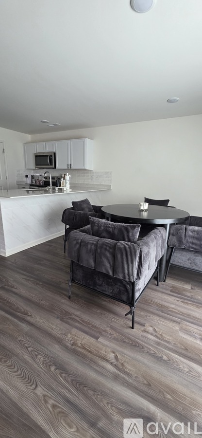 A modern living room with a grey couch and a wooden floor.