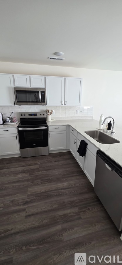 A kitchen with white cabinets and a black oven.