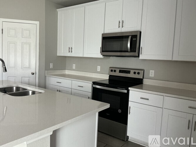A kitchen with white cabinets and a black stove top oven.