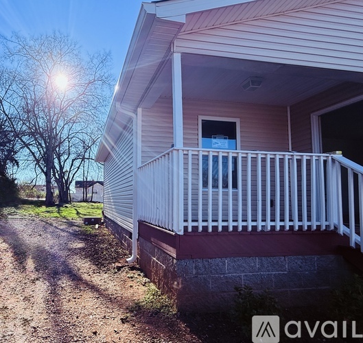 A house with a porch and a sign that says "available" in the foreground.