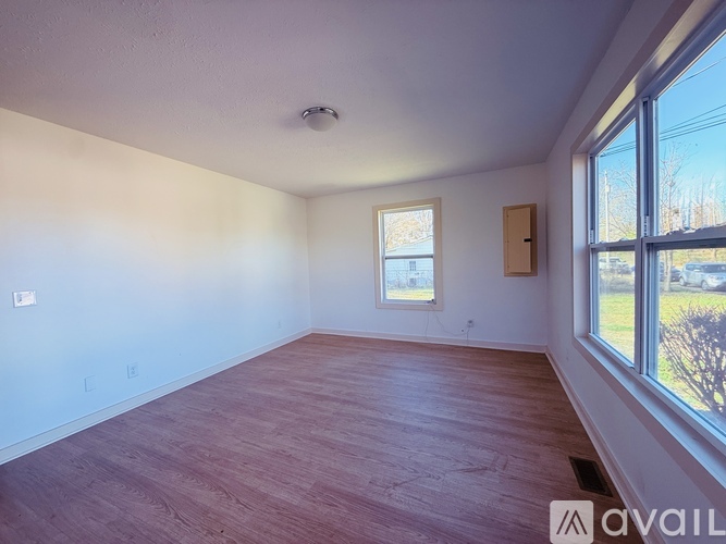 A room with wooden flooring and a window.