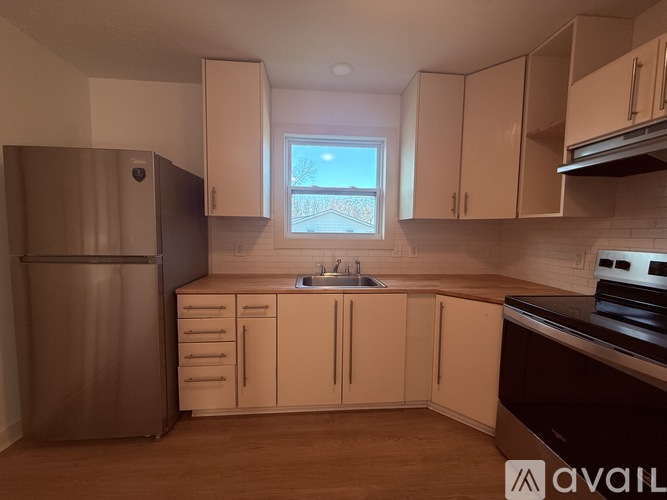 A kitchen with wooden floors and white cabinets.
