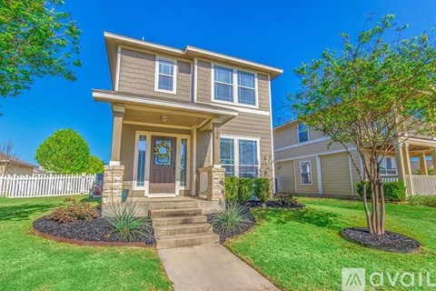 A house with a front yard and a tree in front of it.