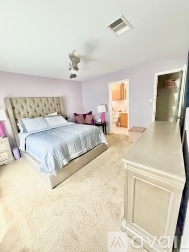 A bedroom with a large bed and a ceiling fan.