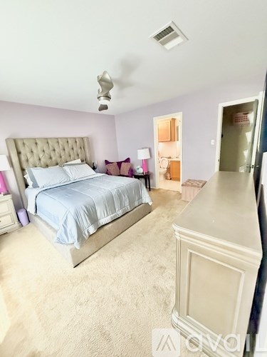 A bedroom with a large bed and a ceiling fan.