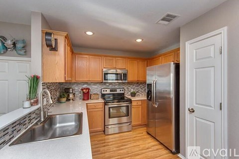 A kitchen with wooden cabinets and stainless steel appliances.