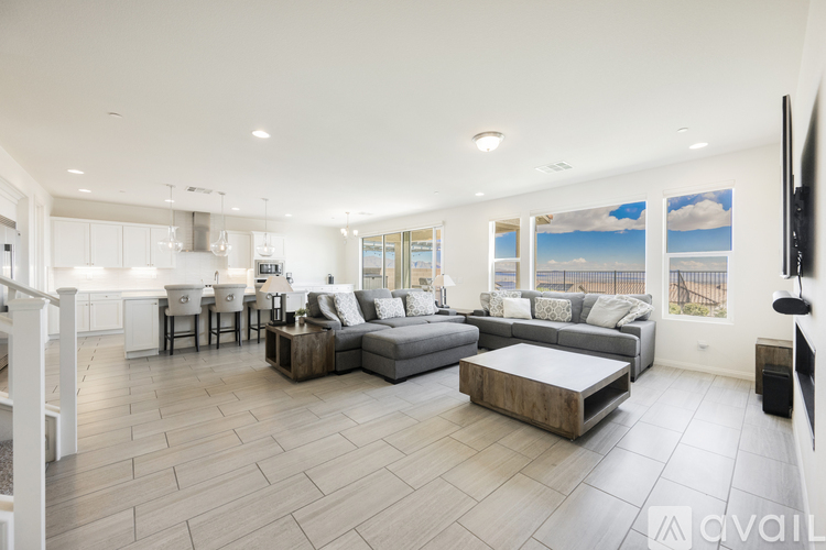 A spacious living room with a grey sofa set and a wooden coffee table.