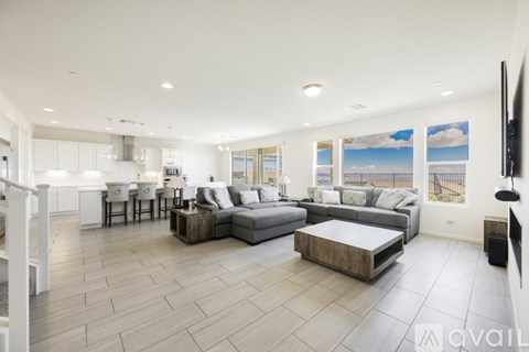 A spacious living room with a grey sofa set and a wooden coffee table.