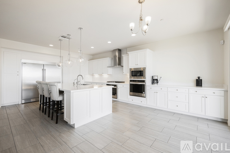 A modern kitchen with white cabinets and a large island.