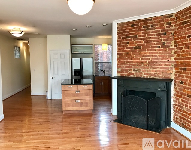 A living room with a fireplace and wooden floors.