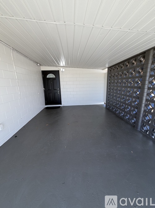 A black door is in a white room with a black floor.
