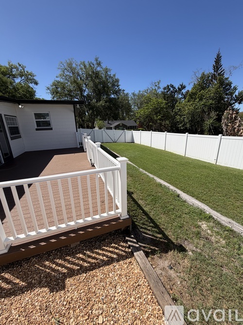 A small white building with a white fence in front of it.