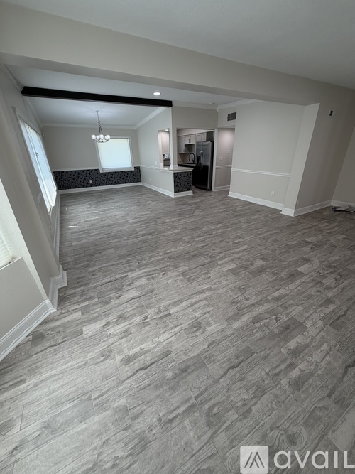 A spacious room with a grey floor and white walls.