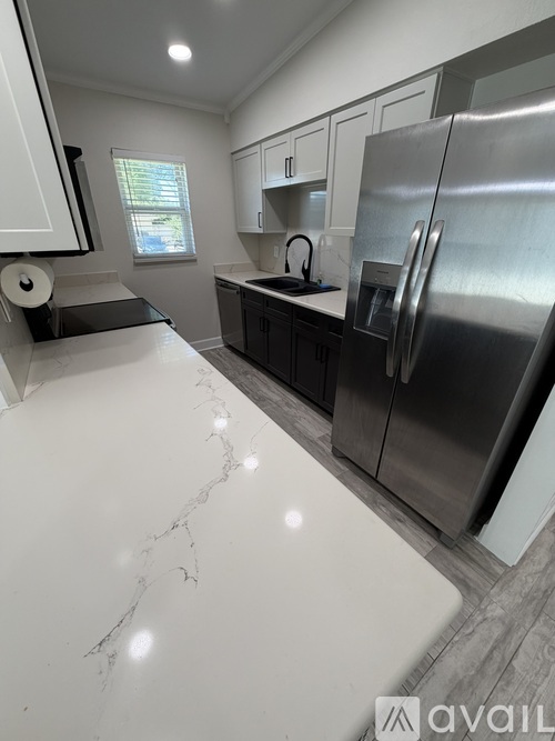 A kitchen with a marble counter top and stainless steel appliances.