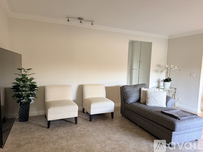 Two chairs and a couch are arranged in a living room.