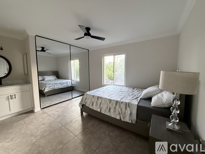 A bedroom with a large bed and a mirror on the wall.