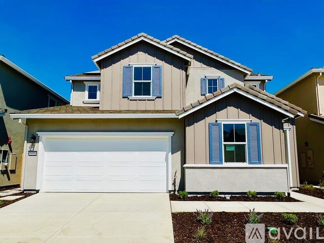 A two-story house with a garage and a driveway.