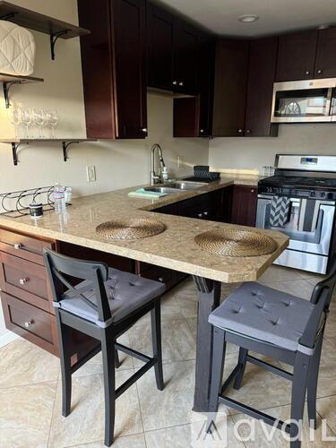 A kitchen with a table and two chairs.