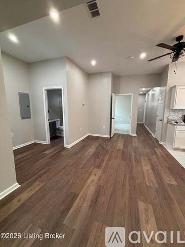 A room with wooden flooring and a ceiling fan.