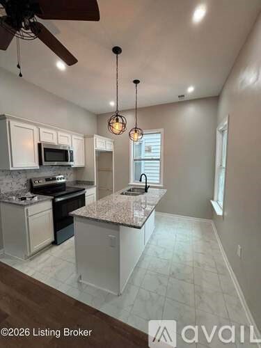A kitchen with a ceiling fan and pendant lights.