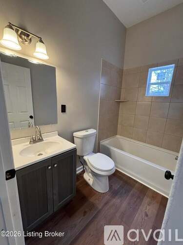A bathroom with a toilet, sink, and bathtub.