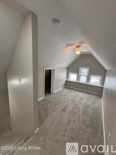 A room with a carpeted floor and a window with a view of a building outside.