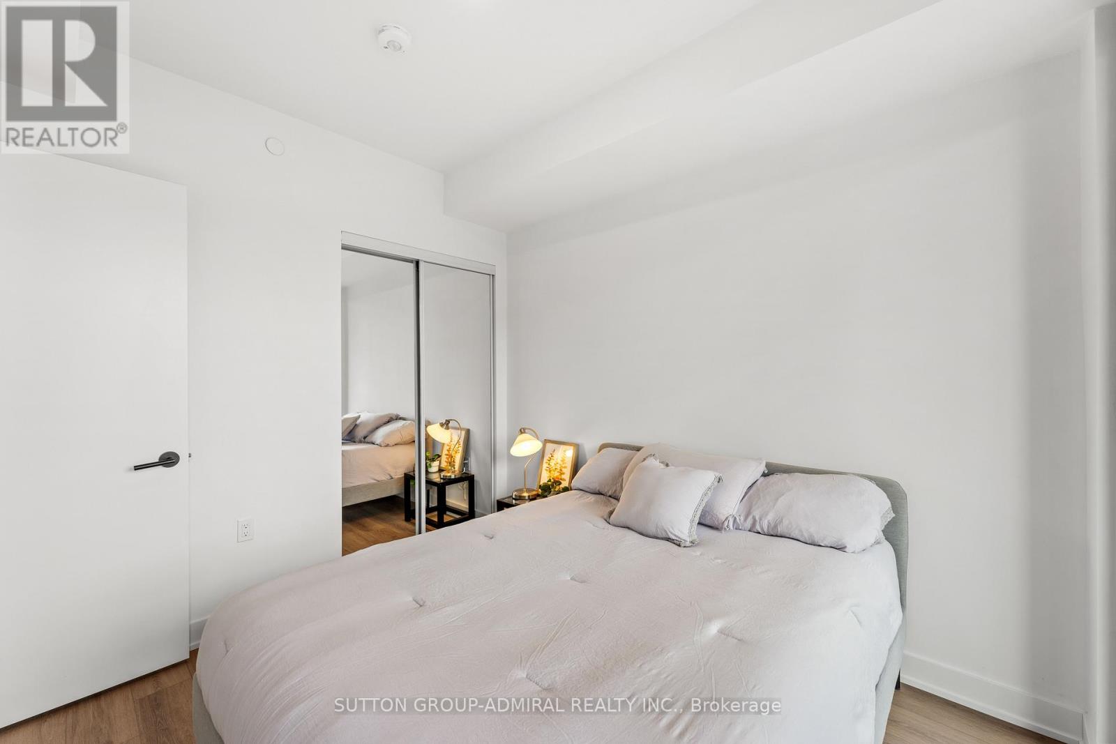 A bedroom with a large bed and a mirror on the wall.