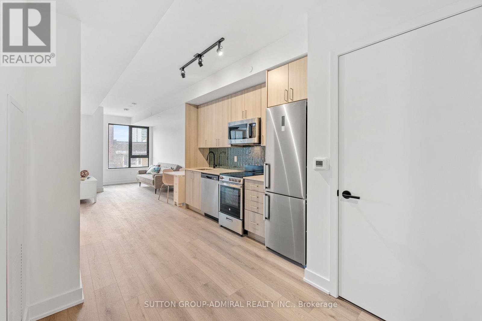 A modern kitchen with a refrigerator, oven, and microwave.