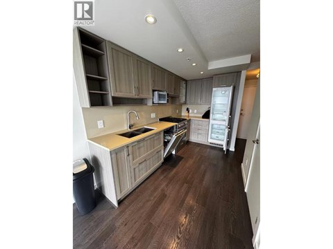 A kitchen with wooden floors and cabinets.
