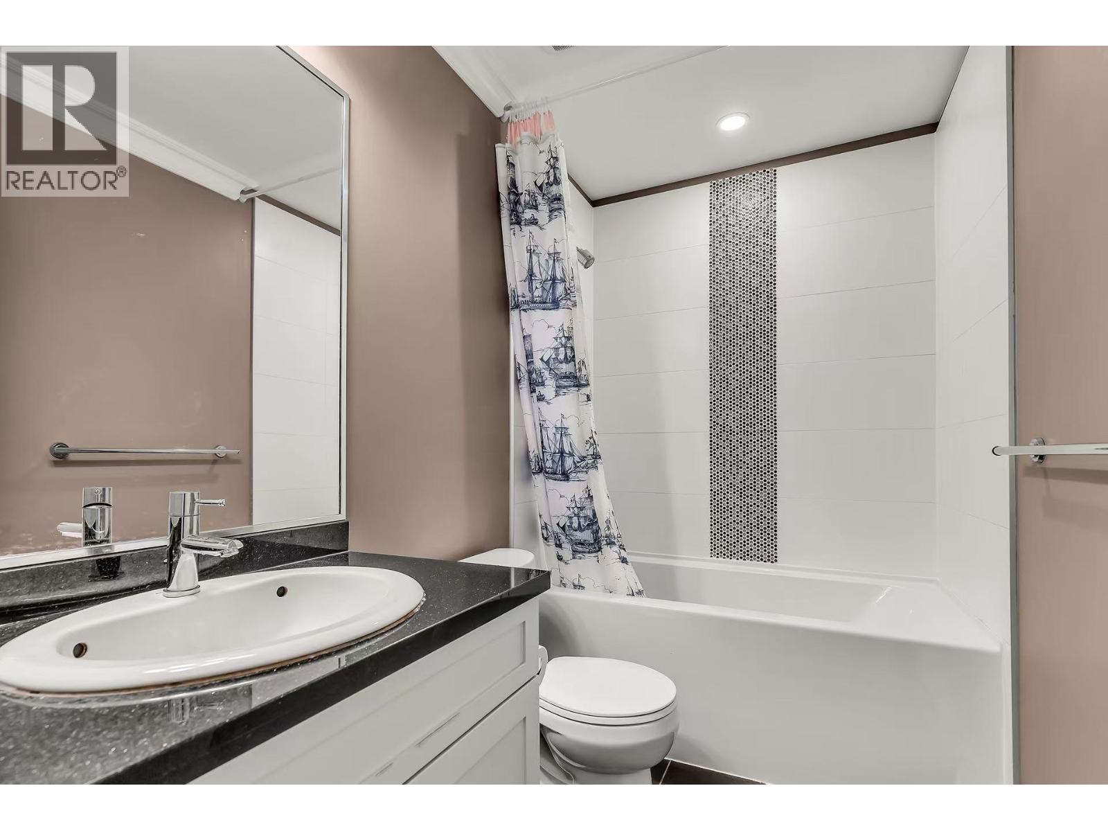 A bathroom with a sink, toilet, and bathtub.