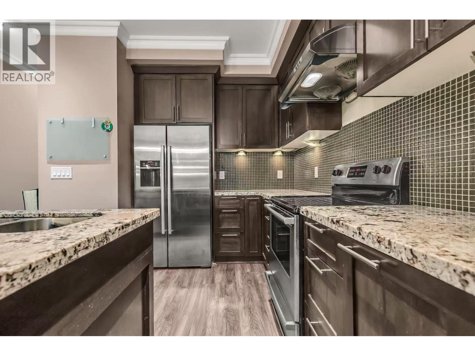 A modern kitchen with granite countertops and stainless steel appliances.