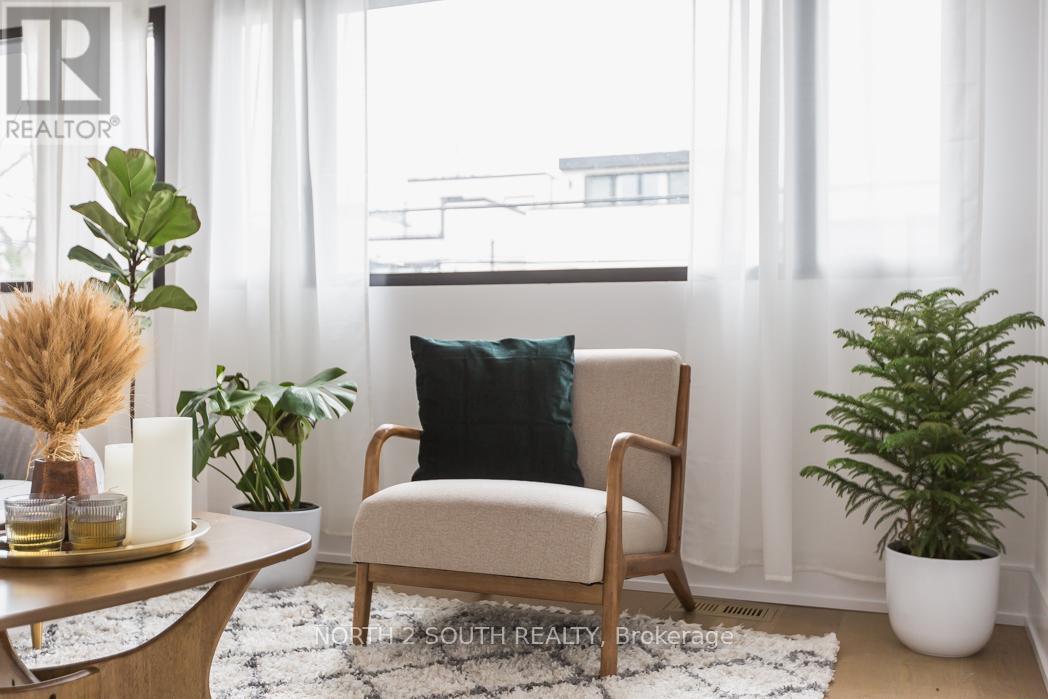 A living room with a chair, a table, and a potted plant.