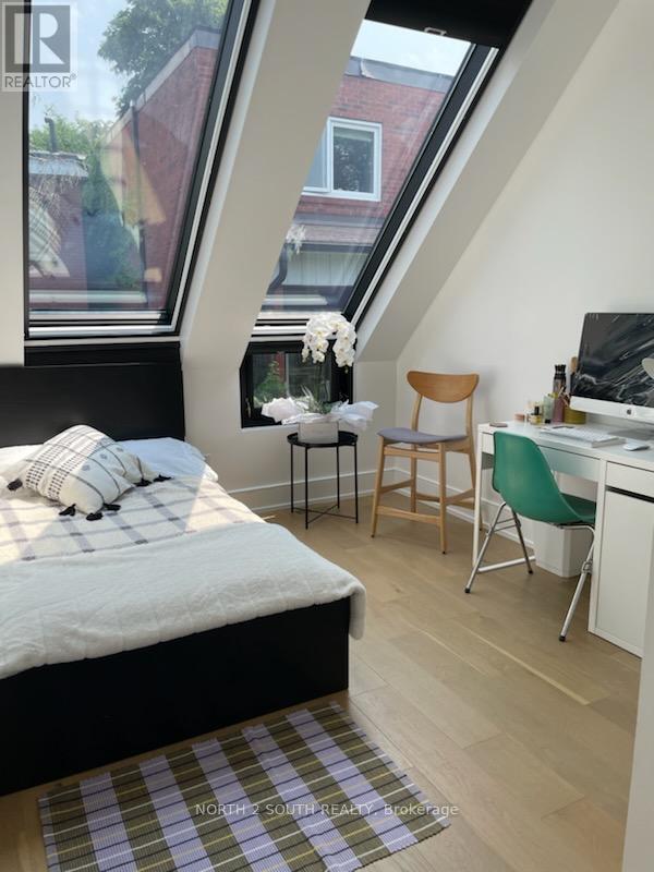 A bedroom with a bed, desk, and chair.