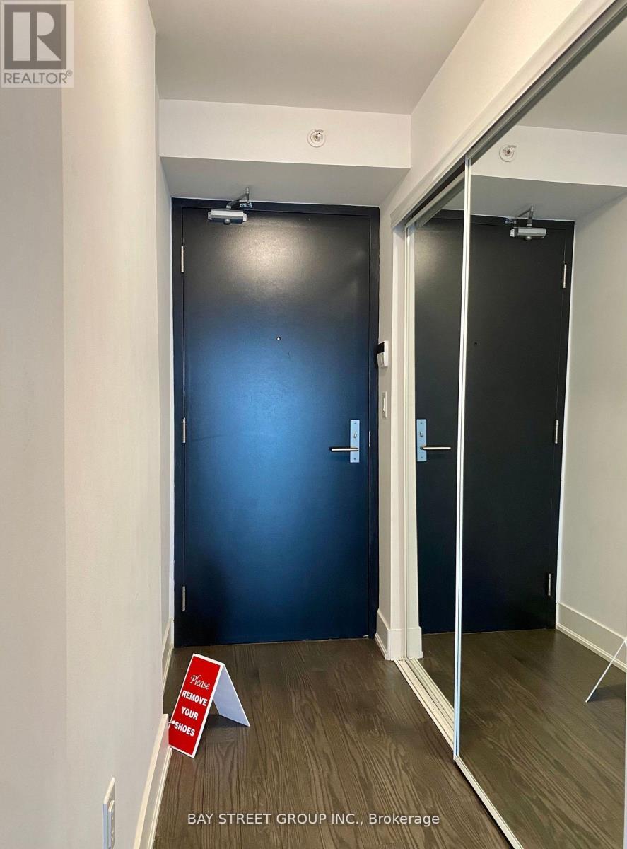 A brokerage office with a blue door and a sign on the floor.