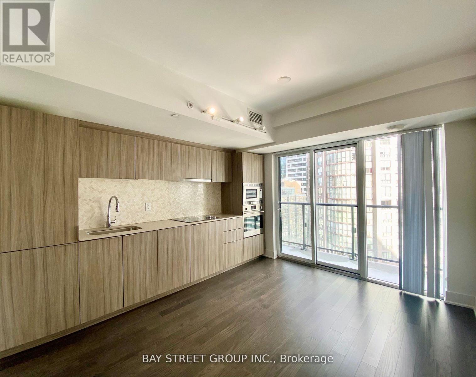 A spacious kitchen with wooden cabinets and a large window.