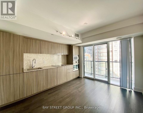 A spacious kitchen with wooden cabinets and a large window.