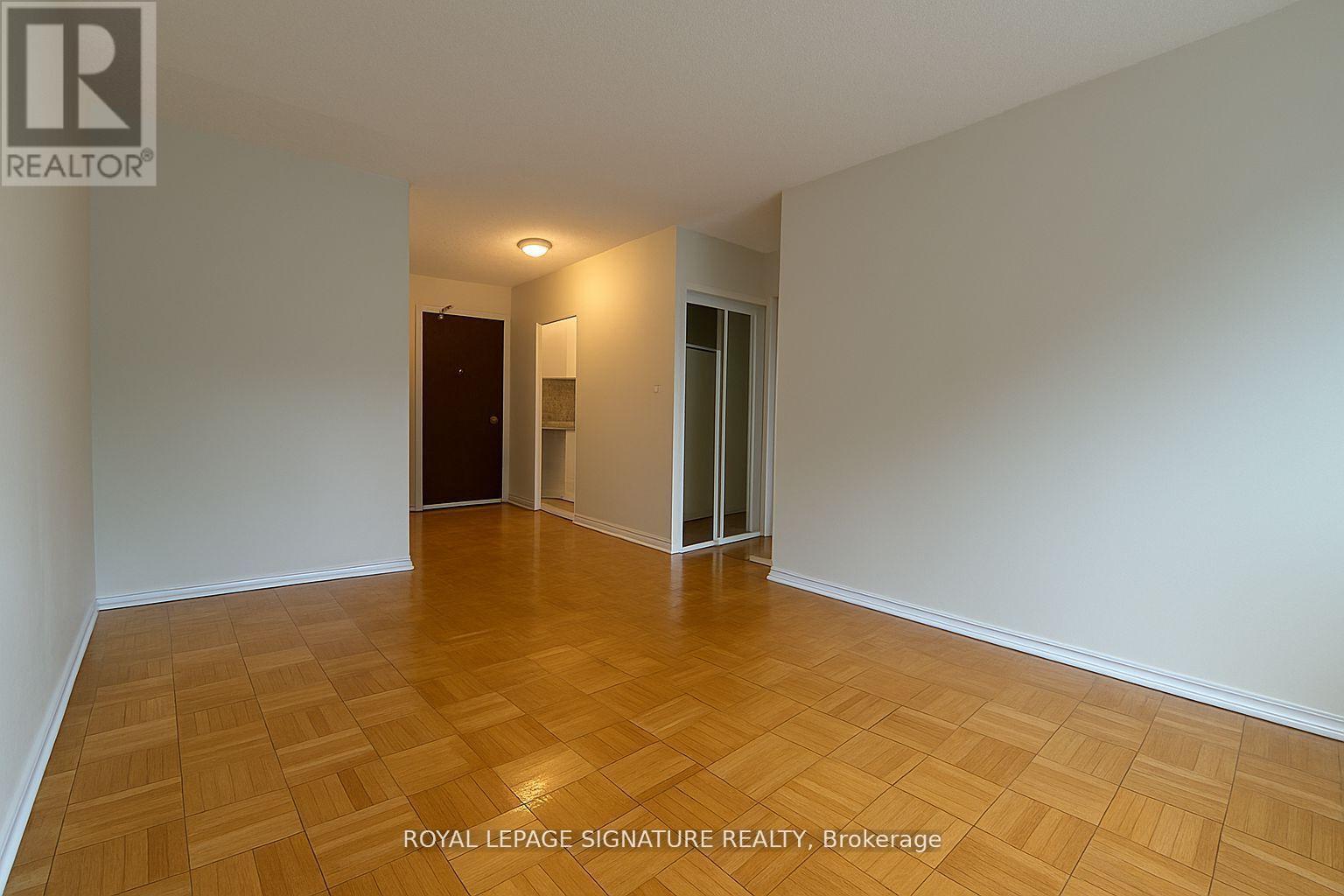 A room with wooden flooring and white walls.