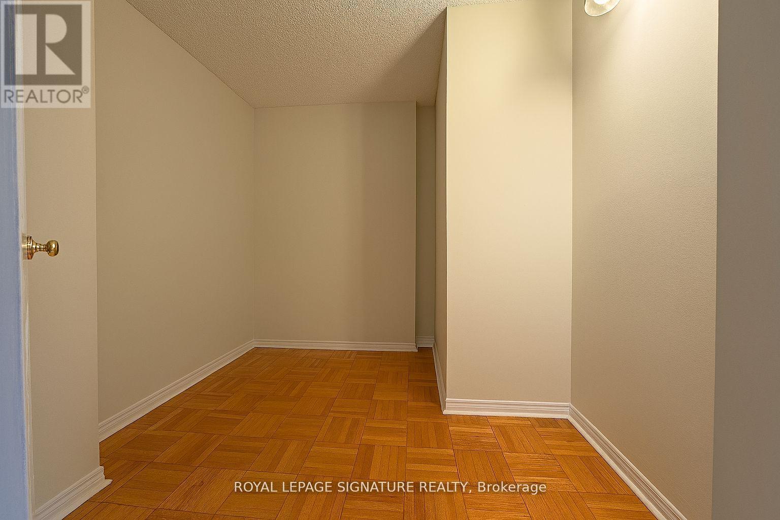 A room with wooden flooring and white walls.