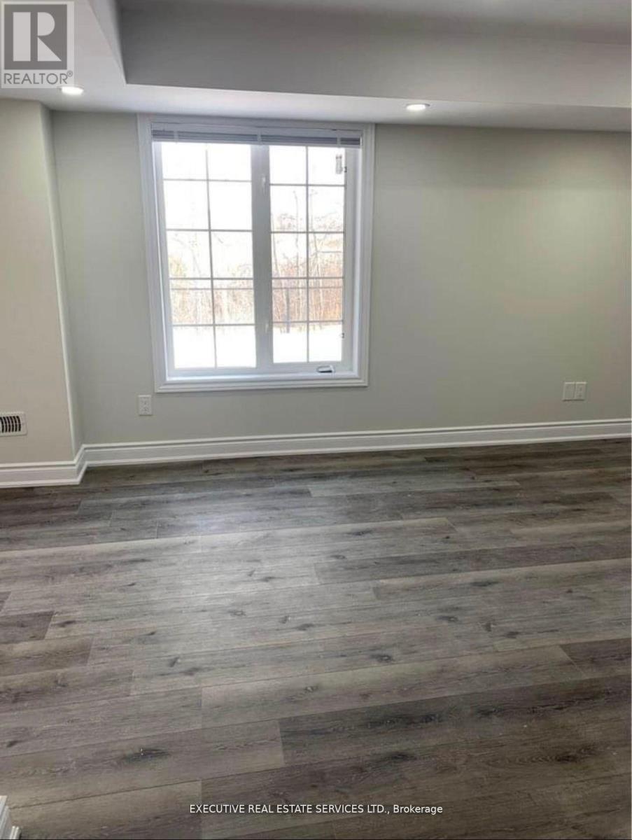 A room with a large window and wooden flooring.