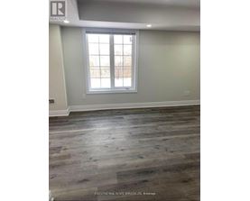 A room with a large window and wooden flooring.