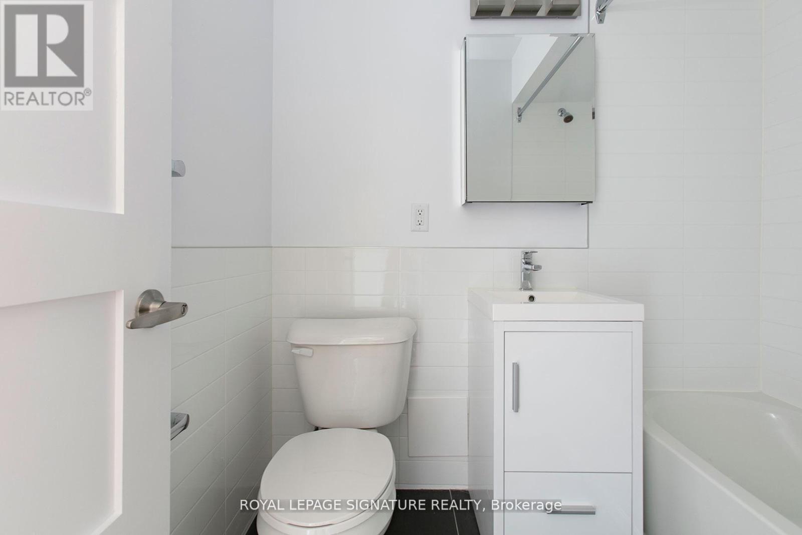 A white bathroom with a toilet, sink, and medicine cabinet.