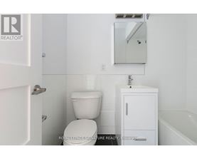 A white bathroom with a toilet, sink, and medicine cabinet.