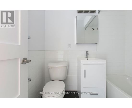 A white bathroom with a toilet, sink, and medicine cabinet.