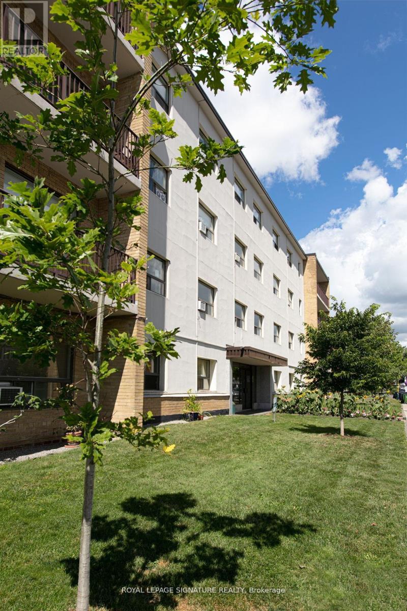 A tree in front of a building with a sign that says "Foyer LePage Signature REALTY Brokerage".