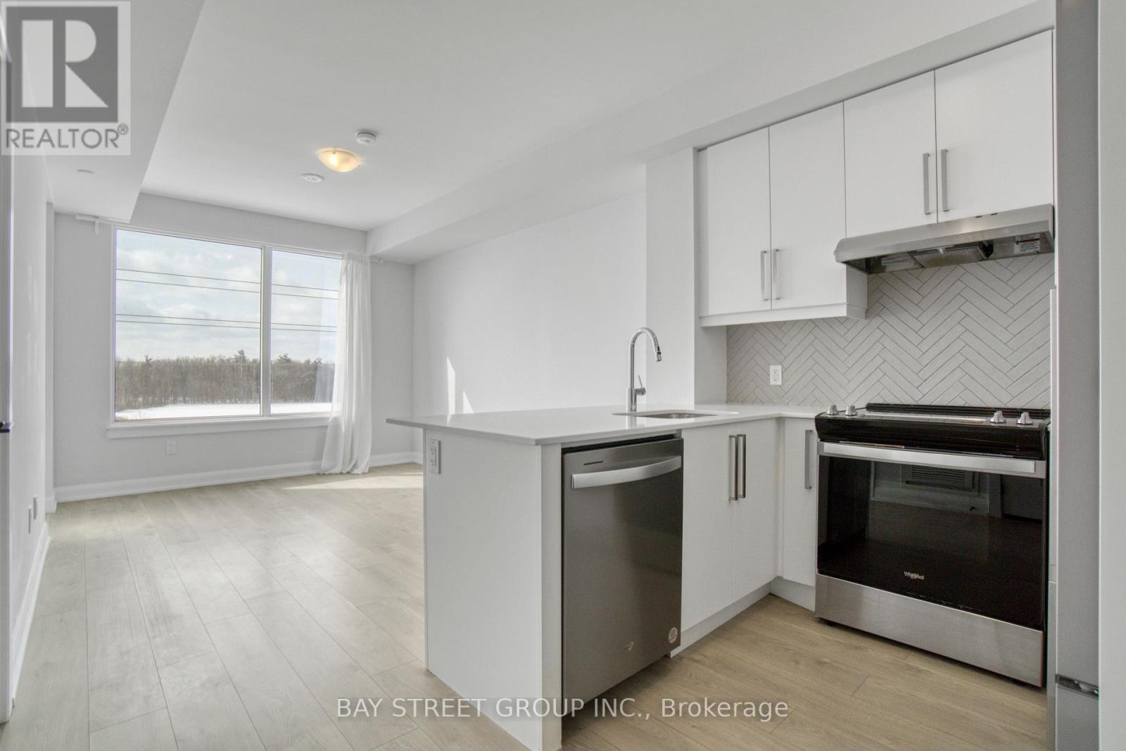 A modern kitchen with white cabinets and stainless steel appliances.