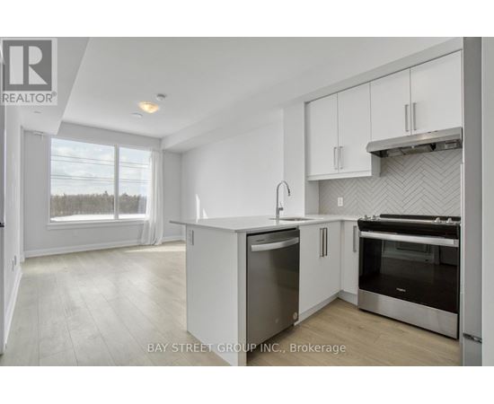 A modern kitchen with white cabinets and stainless steel appliances.
