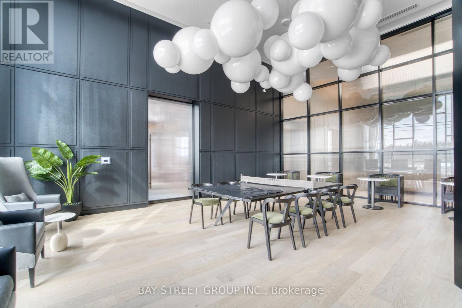 A modern dining room with a table set for six and a large window.